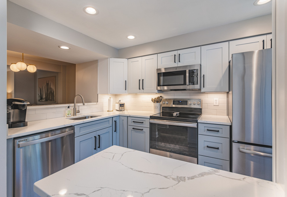 Small eclectic l-shaped medium tone wood floor and multicolored floor eat-in kitchen photo in DC Metro with an undermount sink, shaker cabinets, white cabinets, quartz countertops, white backsplash, ceramic backsplash, stainless steel appliances, no island and gray countertops