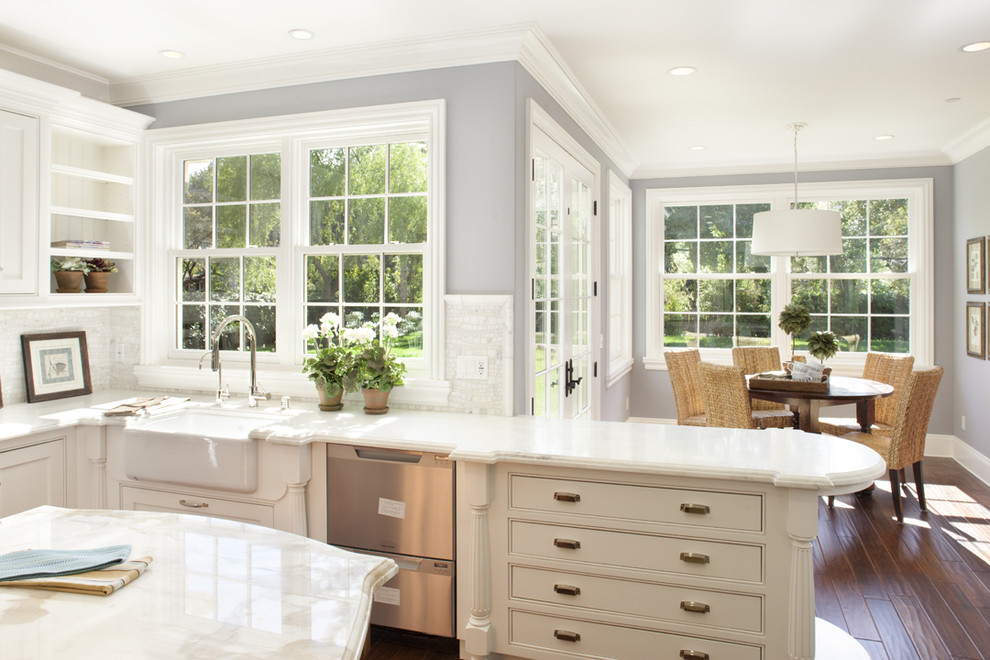 Inspiration for a large traditional l-shaped eat-in kitchen in San Francisco with a farmhouse sink, beaded inset cabinets, white cabinets, marble benchtops, white splashback, mosaic tile splashback, stainless steel appliances, medium hardwood floors and with island.