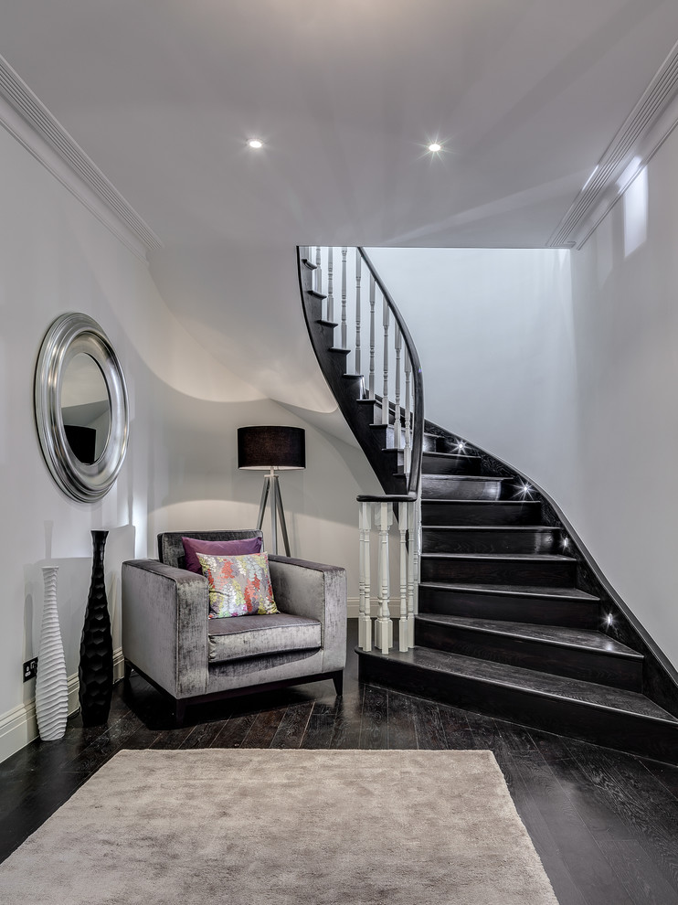 Photo of a contemporary painted wood curved staircase in London with painted wood risers.