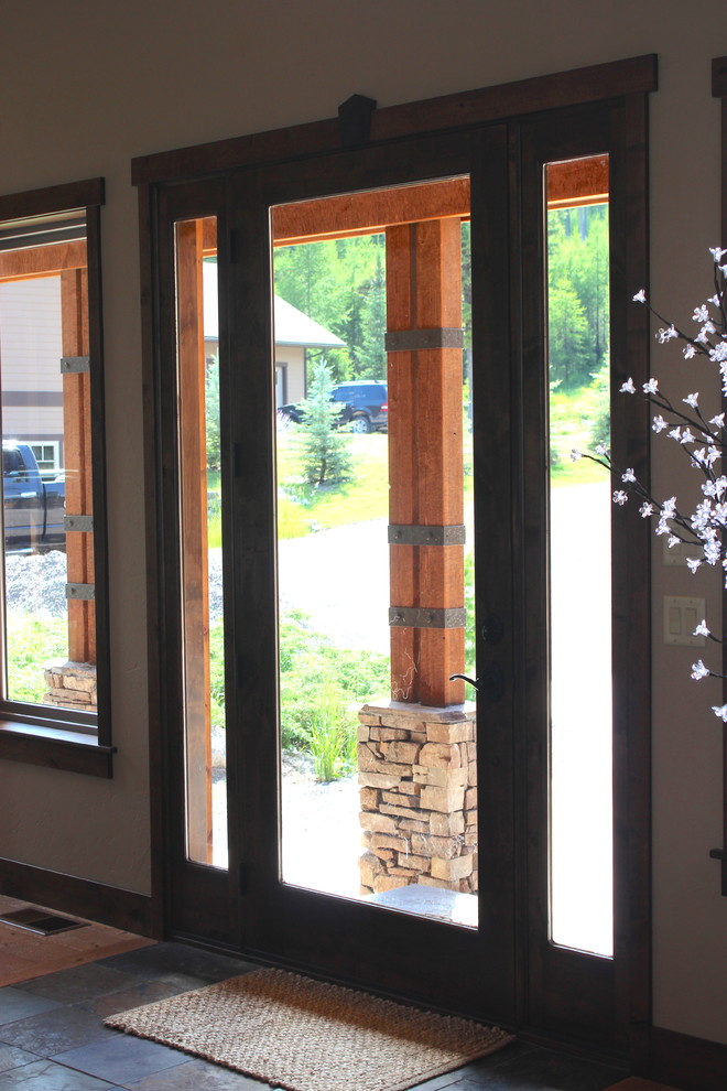 Example of a large transitional slate floor and multicolored floor front door design with beige walls and a glass front door