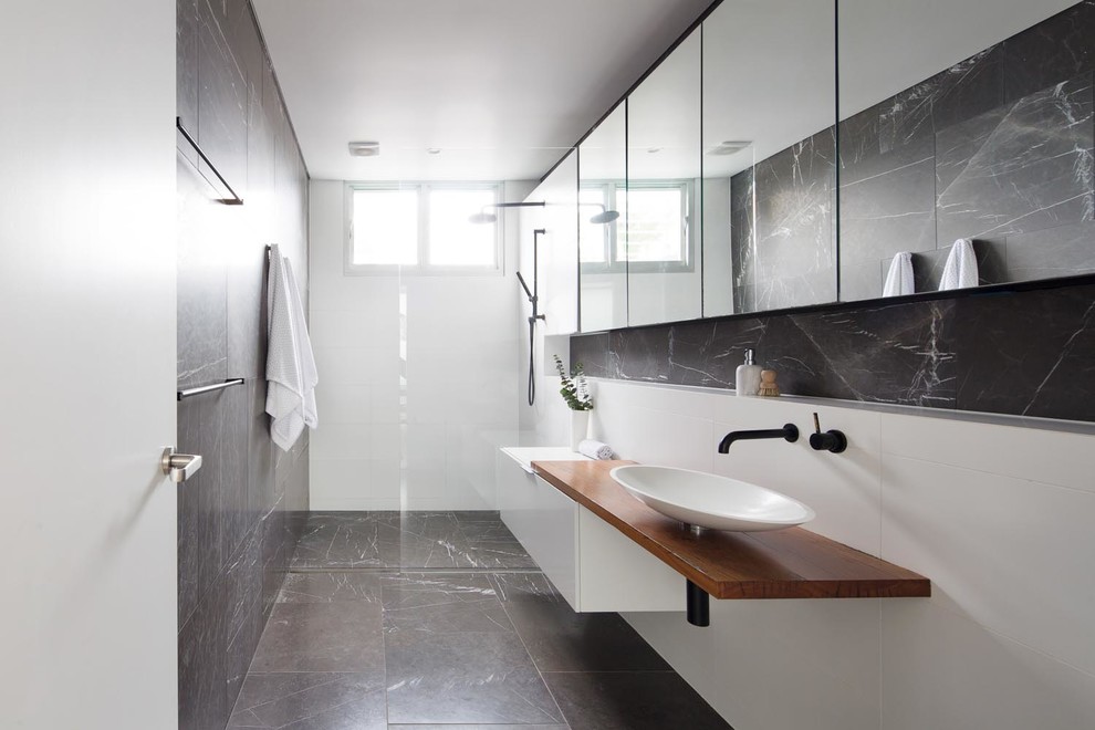 Large contemporary 3/4 bathroom in Sydney with an open shower, porcelain tile, porcelain floors, a vessel sink, wood benchtops, black floor, an open shower, white benchtops, flat-panel cabinets, white cabinets and black and white tile.