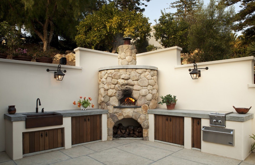 Inspiration for a mid-sized mediterranean backyard patio in Tampa with an outdoor kitchen, stamped concrete and a pergola.
