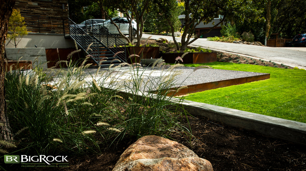 This is an example of a large modern front garden in Salt Lake City with a retaining wall and gravel.