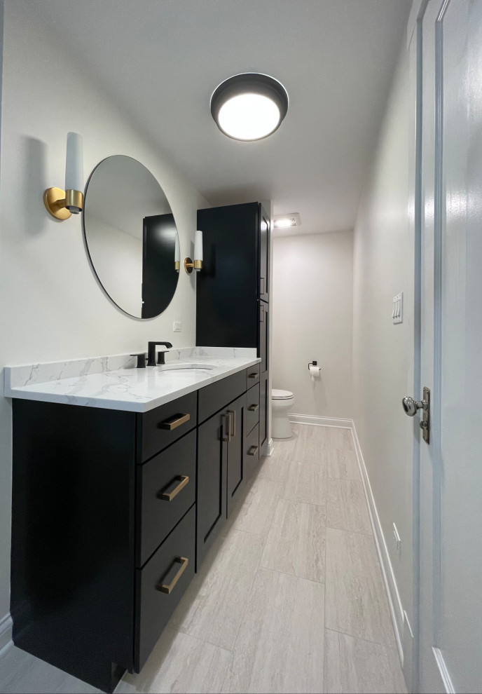 Modelo de cuarto de baño único y de pie de tamaño medio con puertas de armario negras, bañera empotrada, baldosas y/o azulejos blancos y baldosas y/o azulejos de cemento