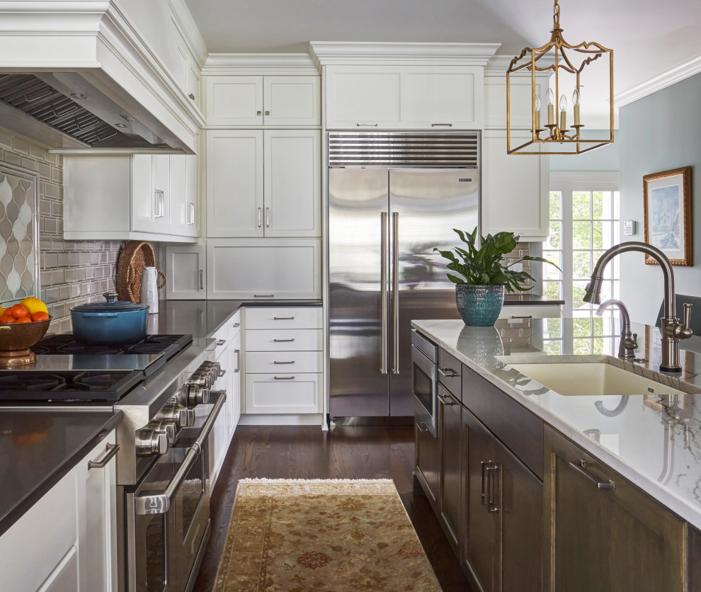 Inspiration for a transitional dark wood floor and brown floor kitchen remodel in Chicago with shaker cabinets, white cabinets, quartz countertops, gray backsplash, ceramic backsplash and black countertops