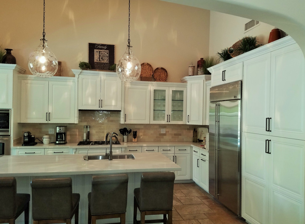 Example of a transitional travertine floor and beige floor kitchen design in Minneapolis with a single-bowl sink, raised-panel cabinets, white cabinets, quartzite countertops, beige backsplash, ceramic backsplash, stainless steel appliances, an island and white countertops