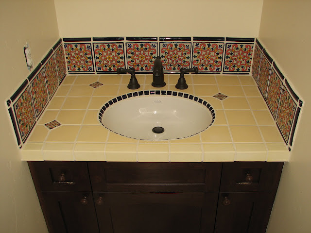 Inspiration for a mid-sized mediterranean 3/4 bathroom in Sacramento with shaker cabinets, dark wood cabinets, an alcove shower, black tile, multi-coloured tile, yellow tile, ceramic tile, beige walls, an integrated sink, tile benchtops, an open shower and yellow benchtops.