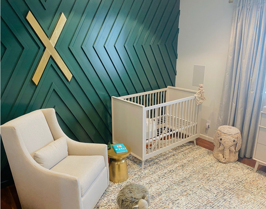 This is an example of a large nursery for boys in San Diego with green walls, carpet and panelled walls.
