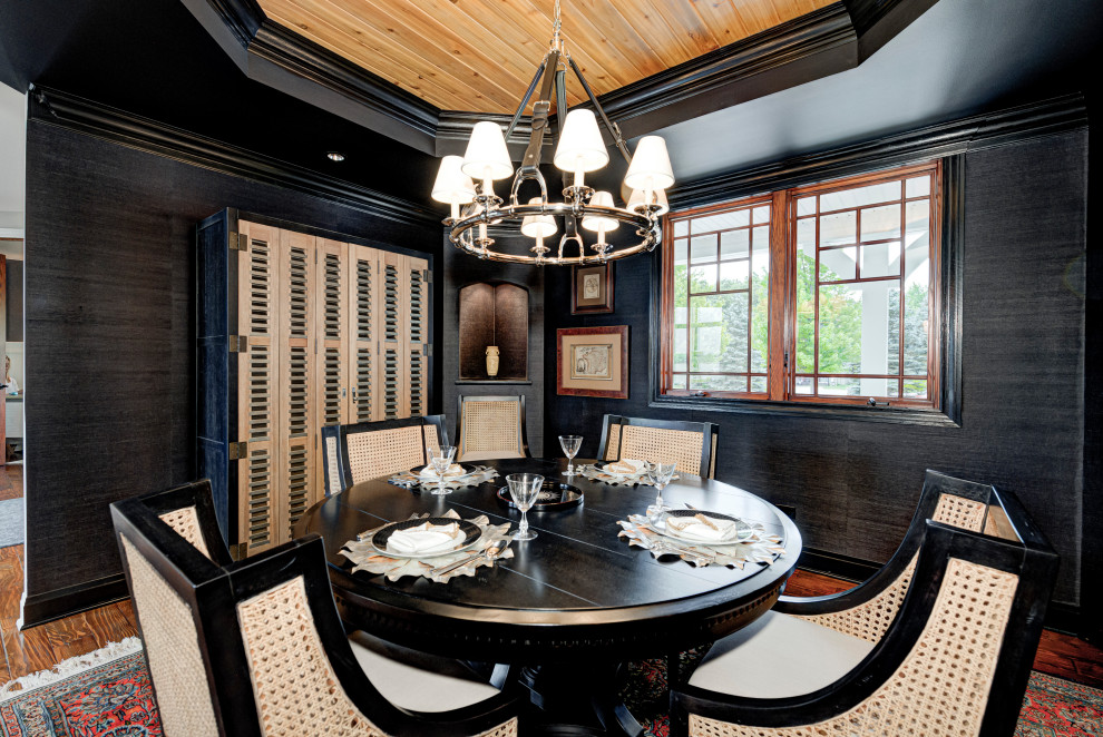 Immagine di una sala da pranzo boho chic chiusa e di medie dimensioni con pavimento in legno massello medio, soffitto in perlinato e pareti nere