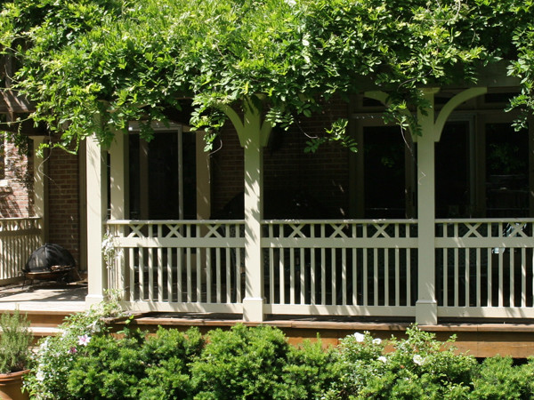 Design ideas for a mid-sized traditional front yard screened-in verandah in DC Metro with decking and a roof extension.