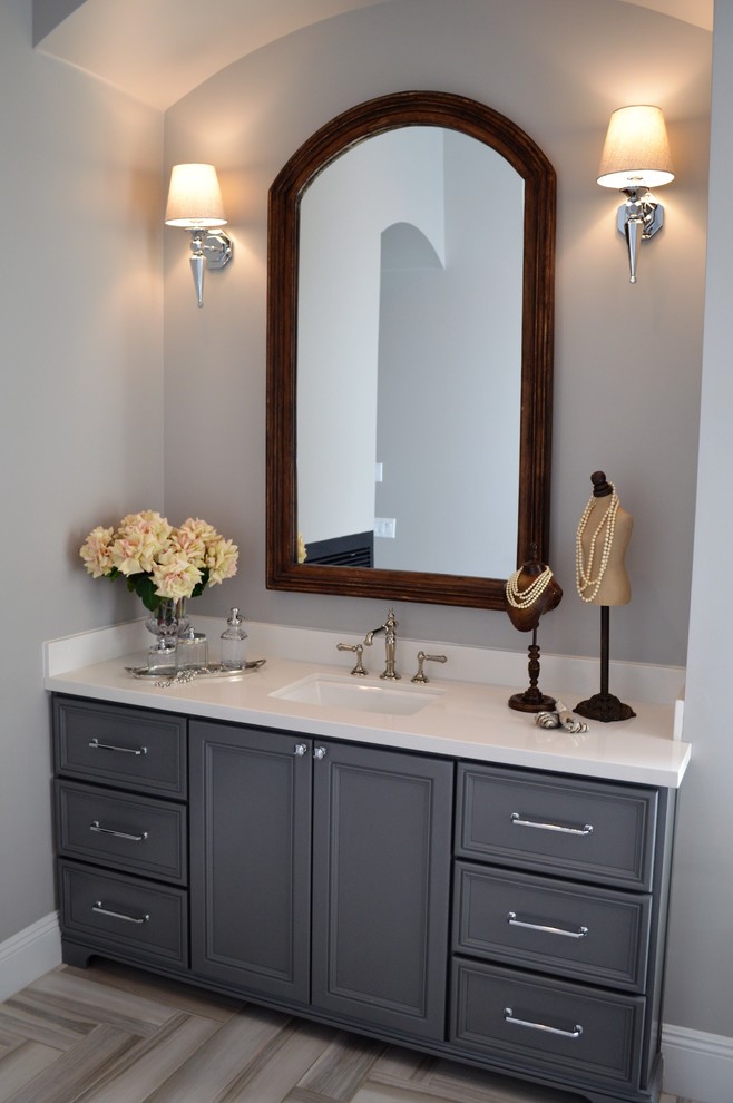Example of a transitional master gray tile and porcelain tile porcelain tile freestanding bathtub design in Phoenix with recessed-panel cabinets, gray cabinets, gray walls, an undermount sink and solid surface countertops