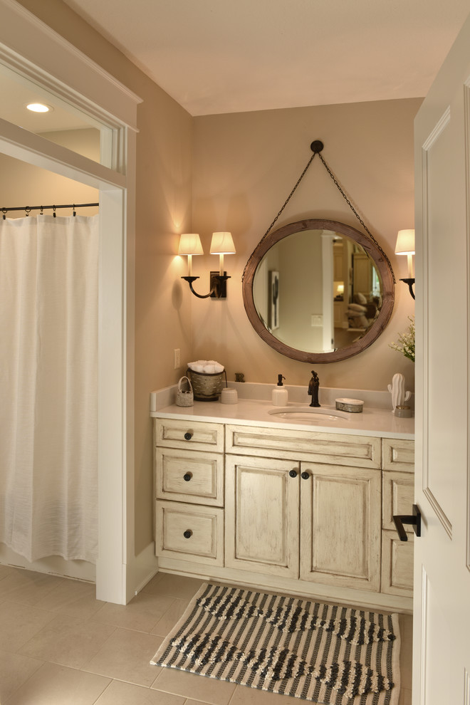 Photo of a mid-sized country master bathroom in Other with flat-panel cabinets, beige cabinets, beige walls, a drop-in sink, granite benchtops and ceramic floors.