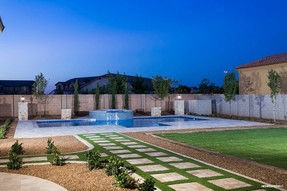 Large transitional two-story stone beige pool photo in Phoenix