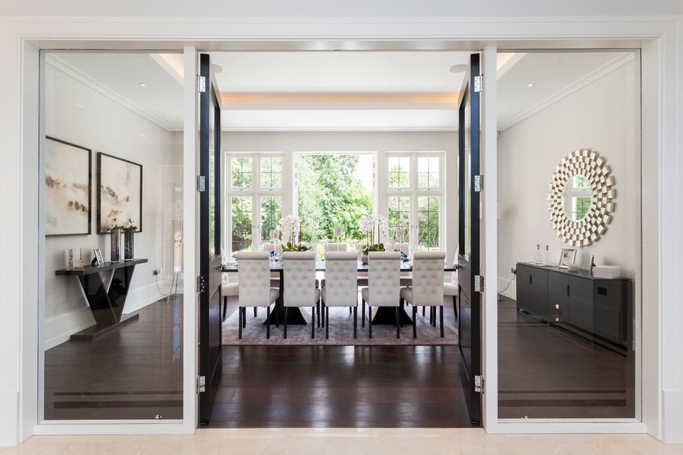 Transitional dining room in London with dark hardwood floors.