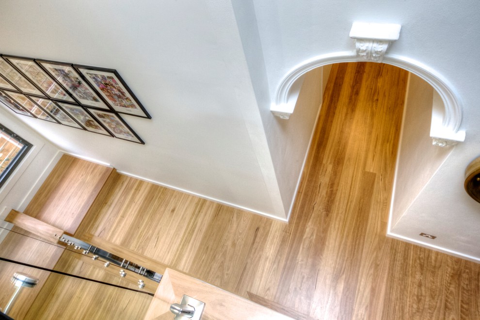 Photo of a mid-sized traditional hallway in Sydney with white walls and light hardwood floors.