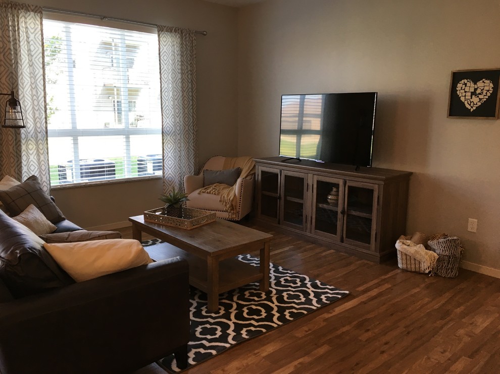 This is an example of a mid-sized traditional open concept living room in Other with beige walls, dark hardwood floors, no fireplace, a freestanding tv and brown floor.