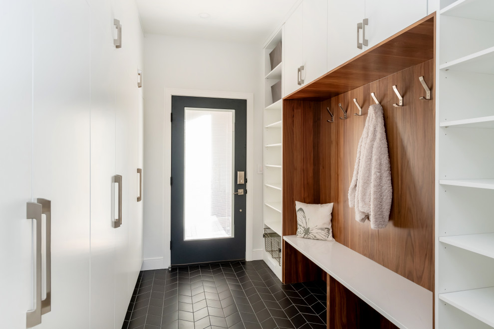 Photo of a mid-sized modern mudroom in Other with white walls, porcelain floors, a single front door, a black front door, black floor and wood.