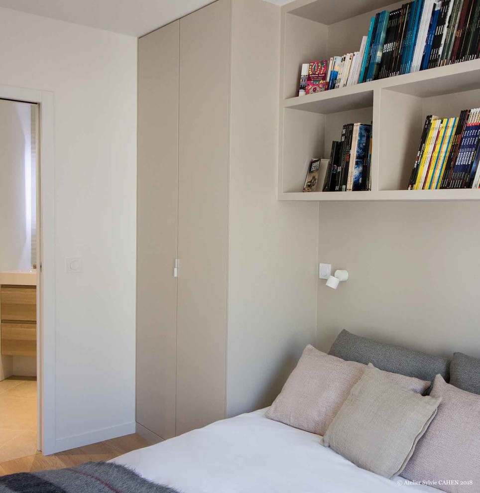 Cette photo montre une chambre parentale tendance de taille moyenne avec un mur blanc, parquet clair, aucune cheminée et un sol marron.