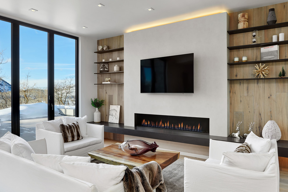 This is an example of a large contemporary open concept family room in Denver with white walls, light hardwood floors, a ribbon fireplace, a plaster fireplace surround, a wall-mounted tv and beige floor.