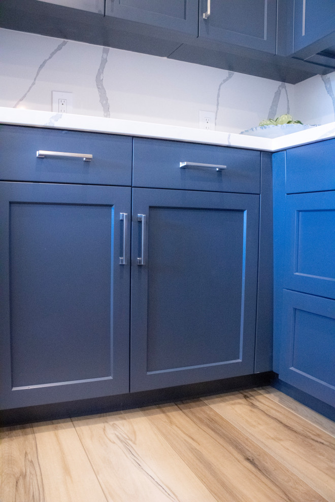 Inspiration for a mid-sized transitional eat-in kitchen remodel in Phoenix with an undermount sink, shaker cabinets, blue cabinets, quartz countertops, white backsplash, quartz backsplash, stainless steel appliances, an island and white countertops