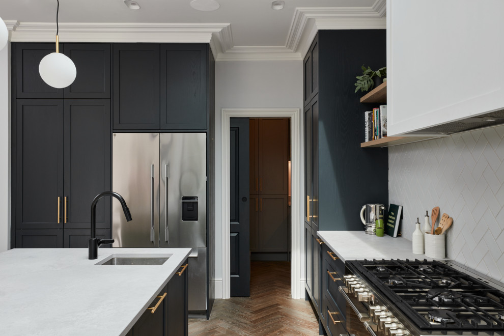 Photo of a large classic l-shaped kitchen pantry in London with a built-in sink, quartz worktops, white splashback, stainless steel appliances and an island.