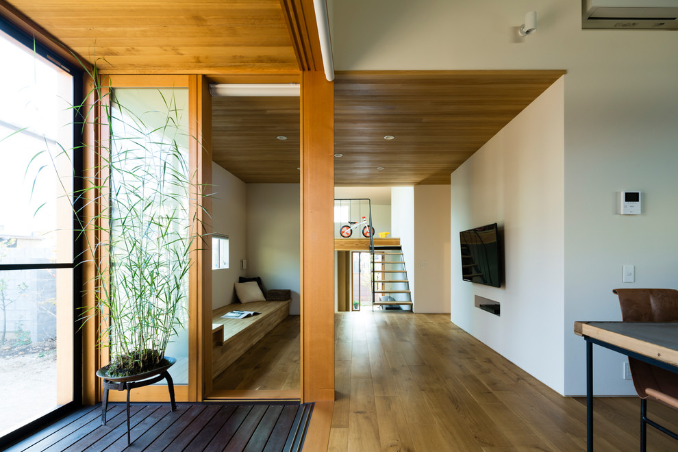 This is an example of an asian hallway in Other with white walls, medium hardwood floors and brown floor.