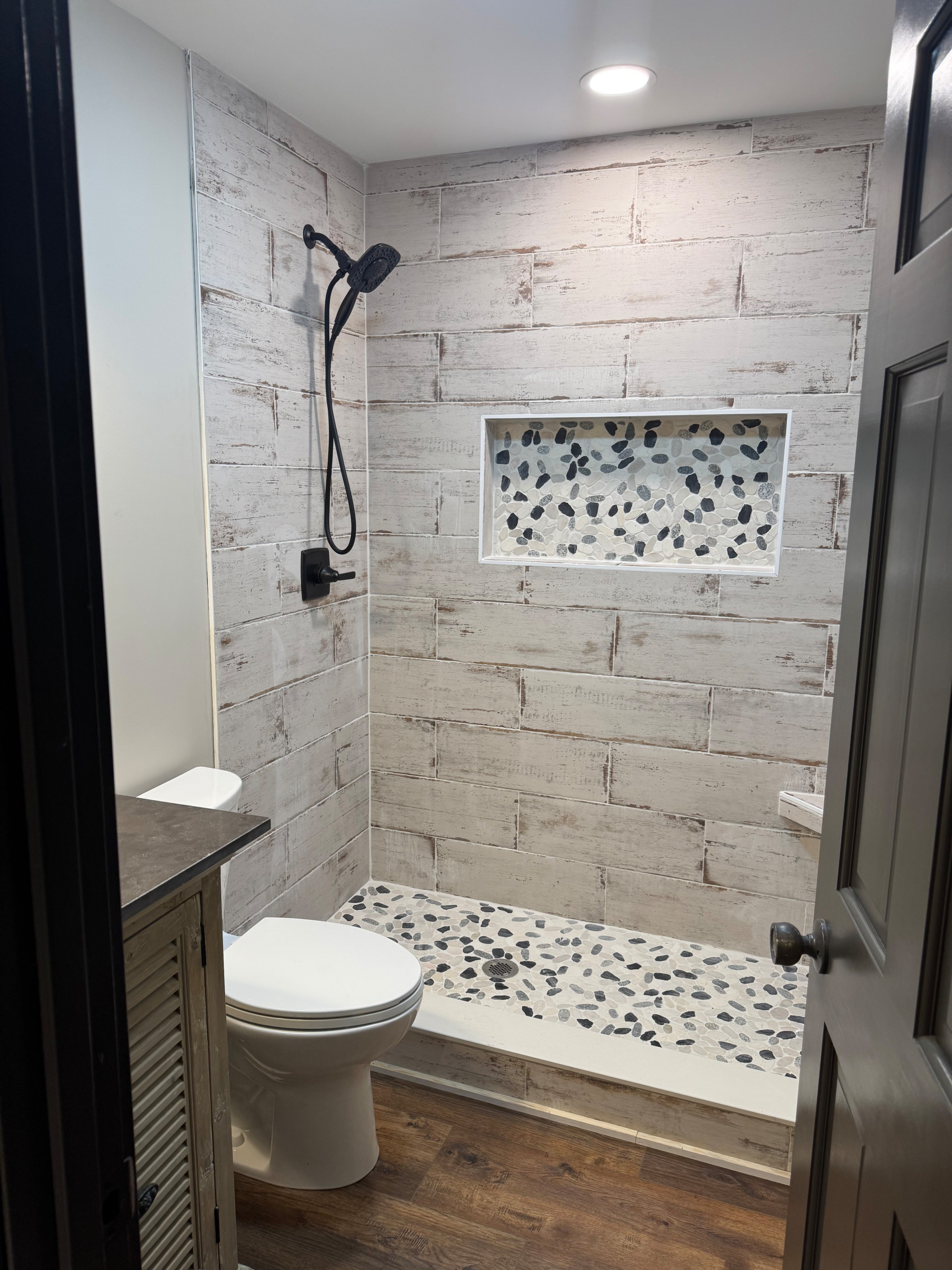 Rustic Farmhouse Bathroom Remodel with Wood-Look Tile and Pebble Shower Floor