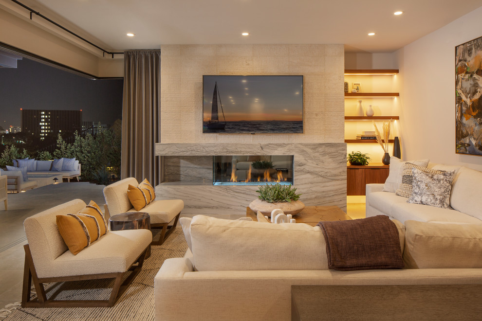 Contemporary open concept living room in Orange County with beige walls, a standard fireplace and a wall-mounted tv.