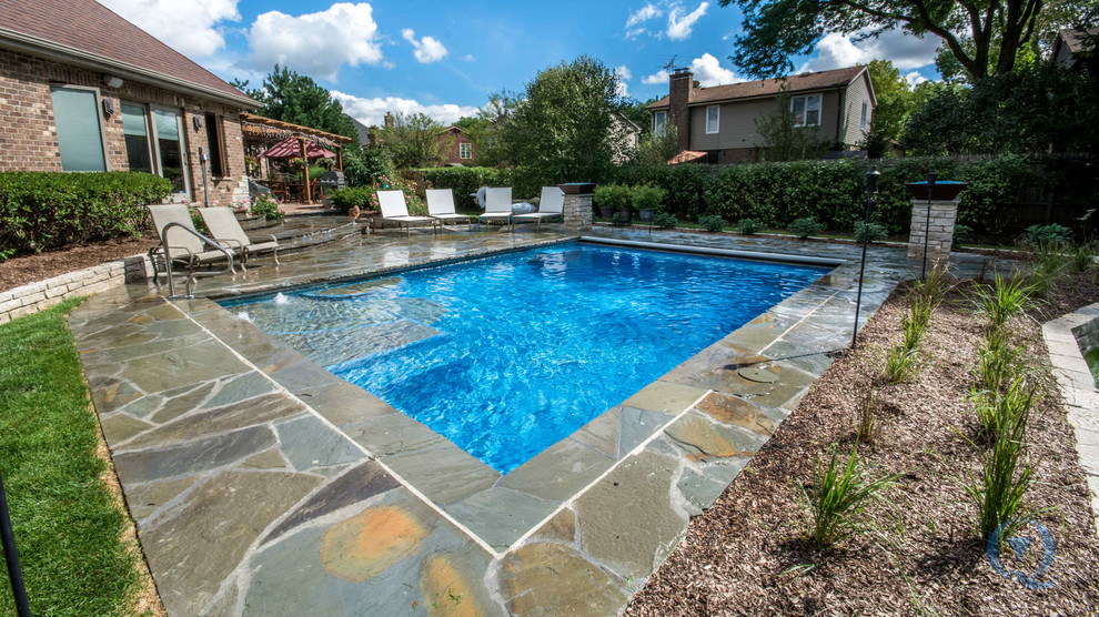 Inspiration for a mid-sized rustic backyard stone and rectangular lap pool fountain remodel in Chicago