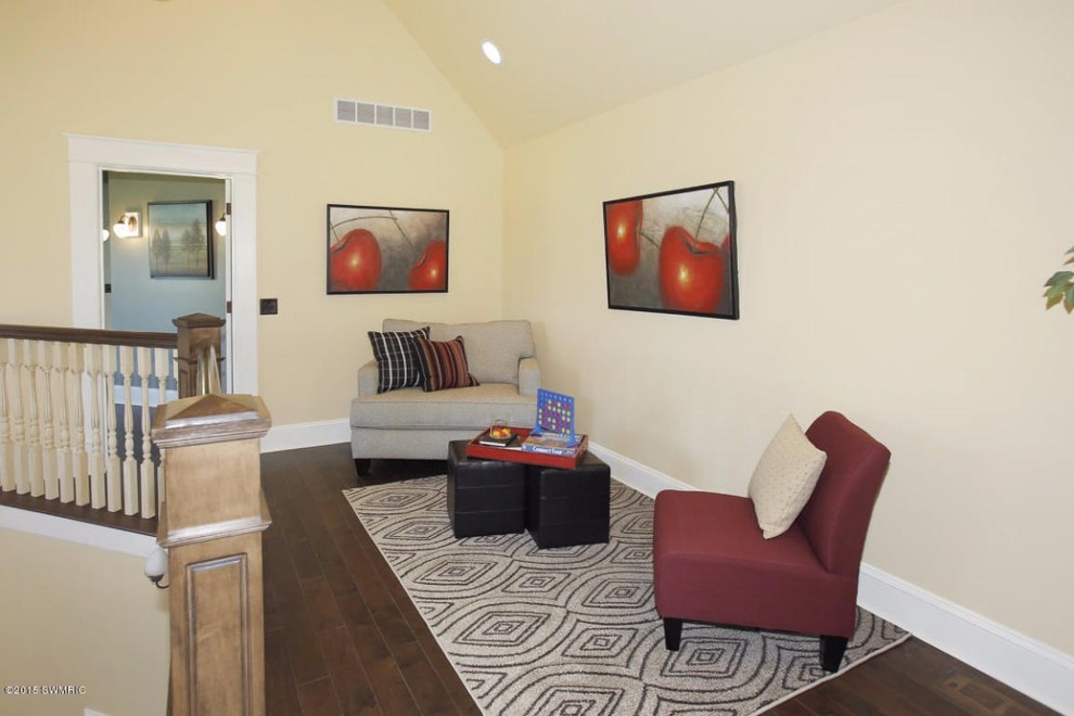 Mid-sized traditional home studio in Grand Rapids with yellow walls and dark hardwood floors.