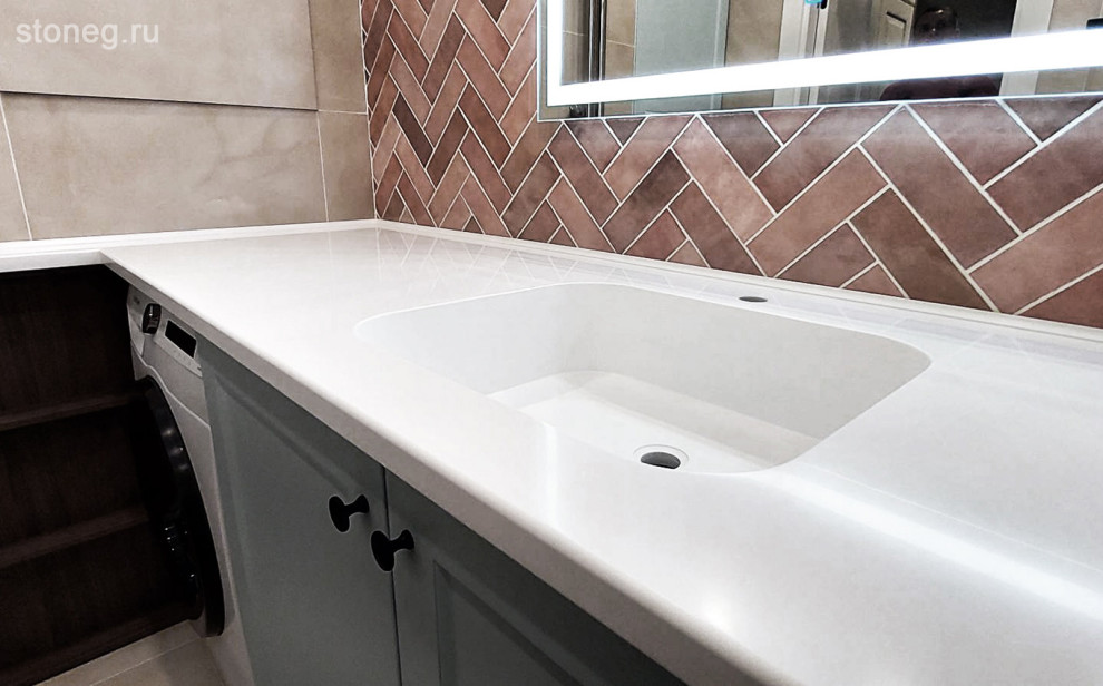 Immagine di una lavanderia multiuso design di medie dimensioni con lavello integrato, top in superficie solida, pareti marroni, pavimento grigio e top bianco