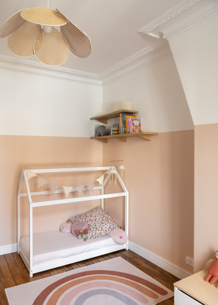 Photo of a large contemporary kids' bedroom for kids 4-10 years old and girls in Paris with pink walls and light hardwood floors.