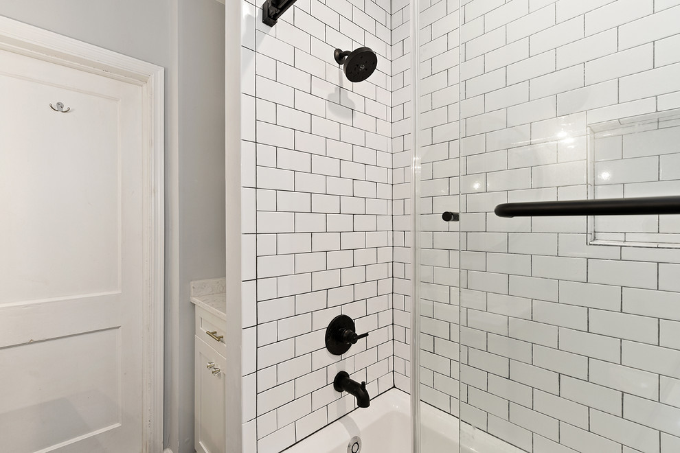 Design ideas for a small modern master bathroom in Jacksonville with open cabinets, white cabinets, a drop-in tub, a shower/bathtub combo, a two-piece toilet, white tile, subway tile, beige walls, ceramic floors, a wall-mount sink, quartzite benchtops, black floor and a sliding shower screen.
