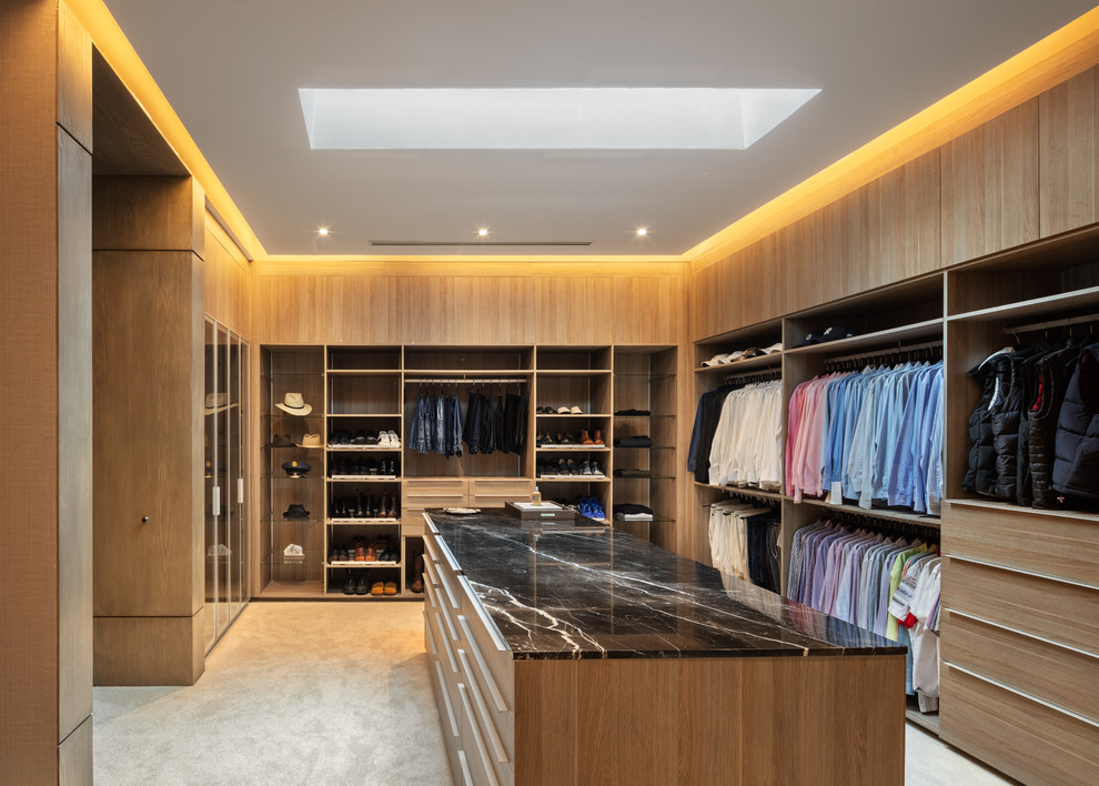 Photo of a contemporary men's walk-in wardrobe with open cabinets and light wood cabinets.