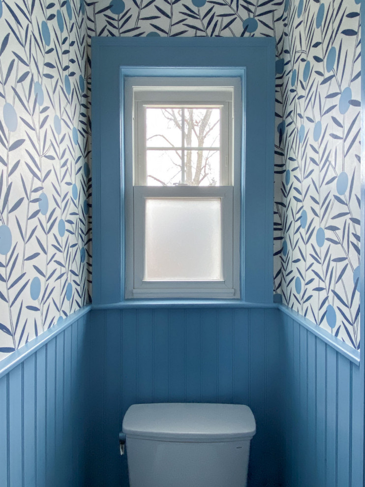 Midcentury powder room in Boston with blue walls, black floor and wallpaper.