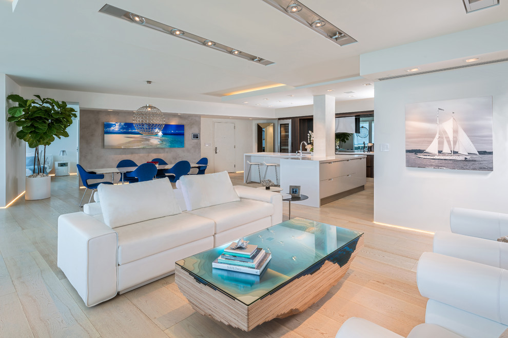 Trendy open concept light wood floor living room photo in Miami with white walls