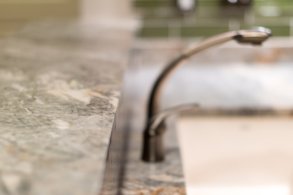 Inspiration for a transitional home design remodel with an undermount sink, granite countertops, green backsplash, stone slab backsplash and stainless steel appliances