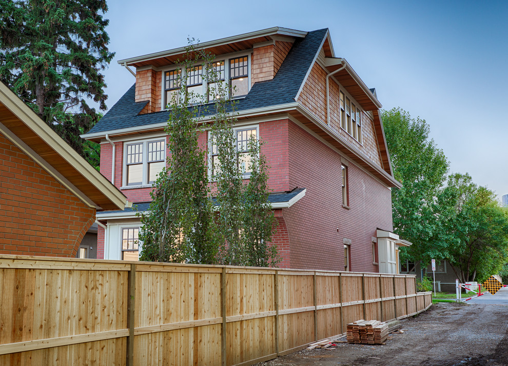 Design ideas for a mid-sized traditional two-storey brick red exterior in Calgary.