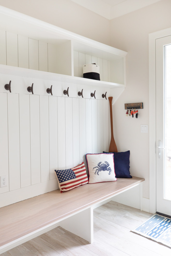 Mid-sized beach style mudroom in Milwaukee with beige walls, medium hardwood floors, a single front door, a white front door and decorative wall panelling.