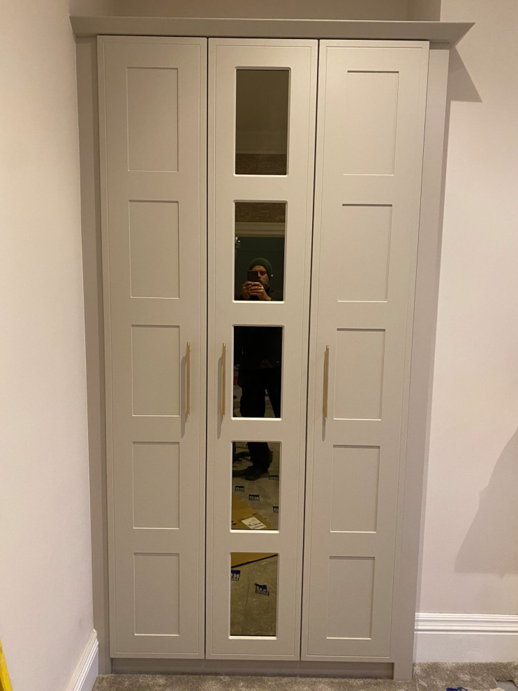 This is an example of a large victorian built-in wardrobe in Other with shaker cabinets, beige cabinets, medium hardwood flooring, yellow floors and feature lighting.