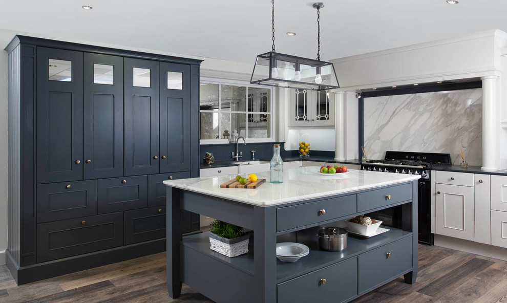Inspiration for a medium sized traditional l-shaped kitchen/diner with a belfast sink, beaded cabinets, grey cabinets, marble worktops, grey splashback, marble splashback, black appliances, medium hardwood flooring and an island.