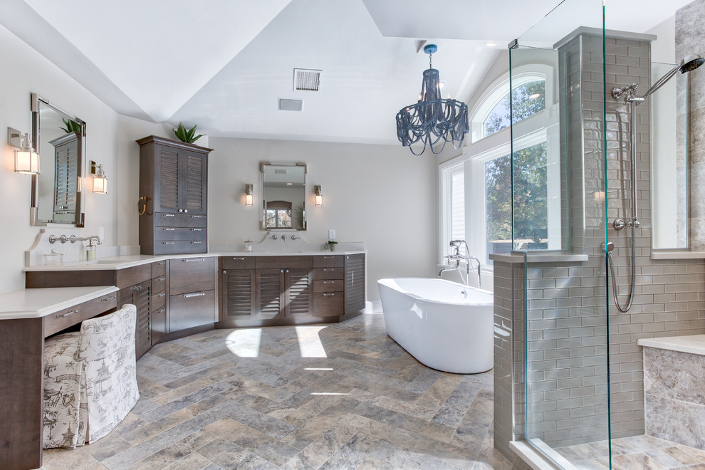 Expansive beach style master bathroom in Denver with louvered cabinets, medium wood cabinets, a freestanding tub, a corner shower, a two-piece toilet, multi-coloured tile, glass tile, beige walls, ceramic floors, an undermount sink and engineered quartz benchtops.