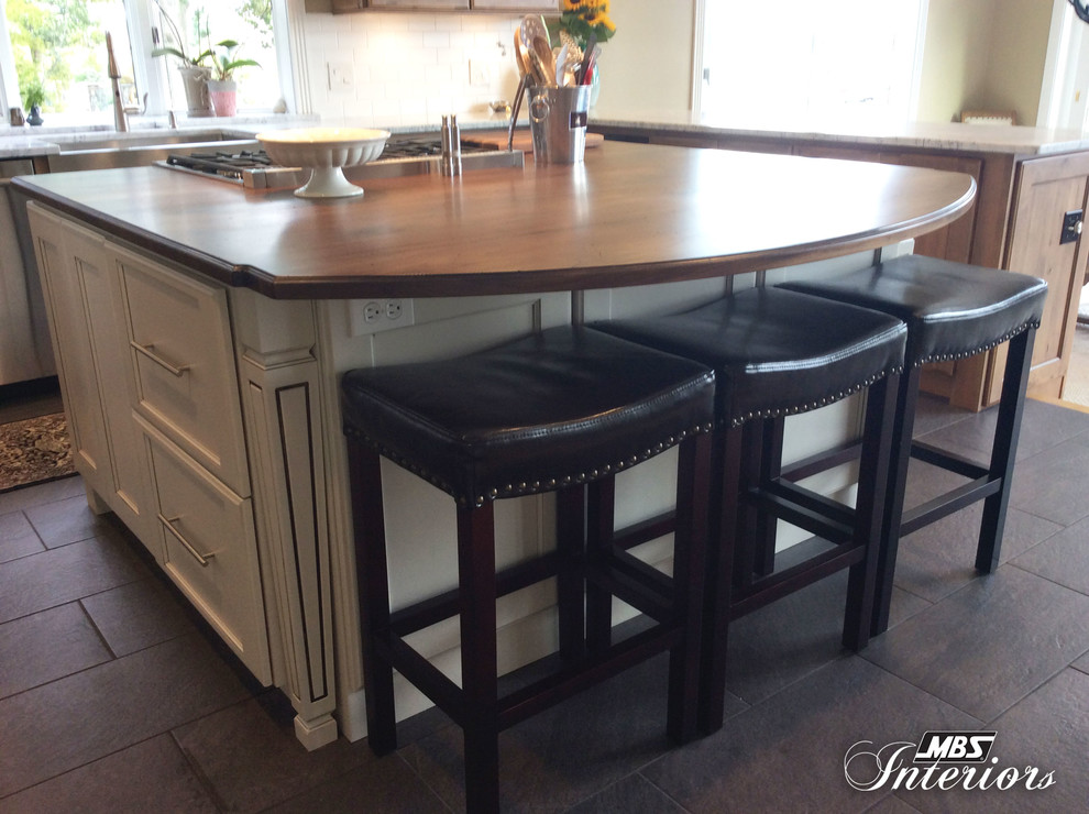 Mid-sized transitional u-shaped ceramic tile and gray floor eat-in kitchen photo with a farmhouse sink, recessed-panel cabinets, medium tone wood cabinets, marble countertops, white backsplash, subway tile backsplash, stainless steel appliances and an island