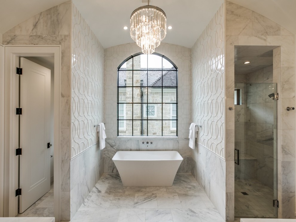 This is an example of a large transitional master bathroom in Dallas with grey cabinets, a freestanding tub, white tile, marble floors, an undermount sink, marble benchtops, beige walls and a hinged shower door.