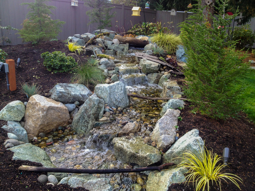 Inspiration for a mid-sized rustic full sun backyard stone water fountain landscape in Seattle for spring.