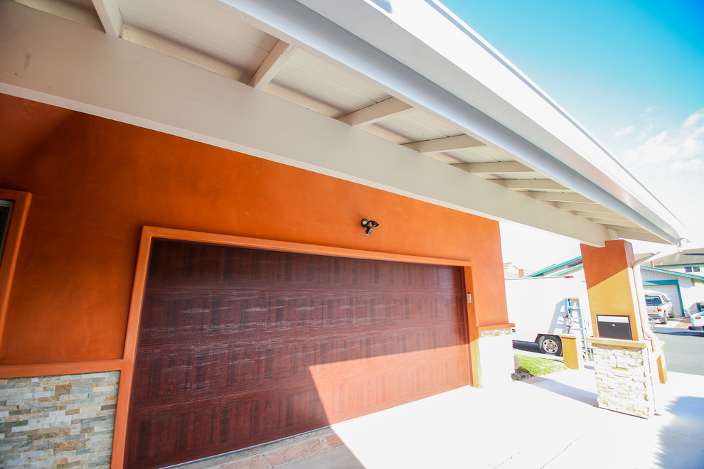This is an example of a mid-sized midcentury one-storey stucco house exterior in Orange County with a gable roof.
