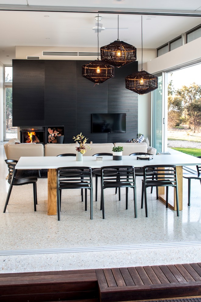 Inspiration for a large modern open plan dining in Adelaide with black walls, concrete floors, a corner fireplace and a metal fireplace surround.