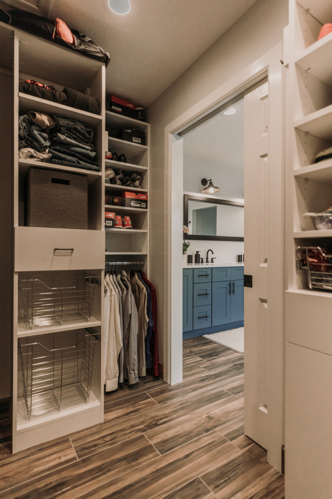 Inspiration for a mid-sized transitional gender-neutral walk-in wardrobe in Albuquerque with flat-panel cabinets, white cabinets, vinyl floors and multi-coloured floor.