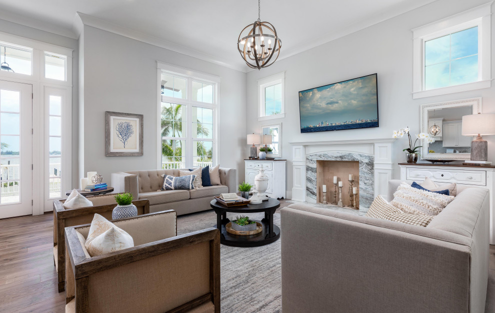 Family room - large coastal open concept light wood floor and vaulted ceiling family room idea in Tampa with blue walls, a standard fireplace and a stone fireplace