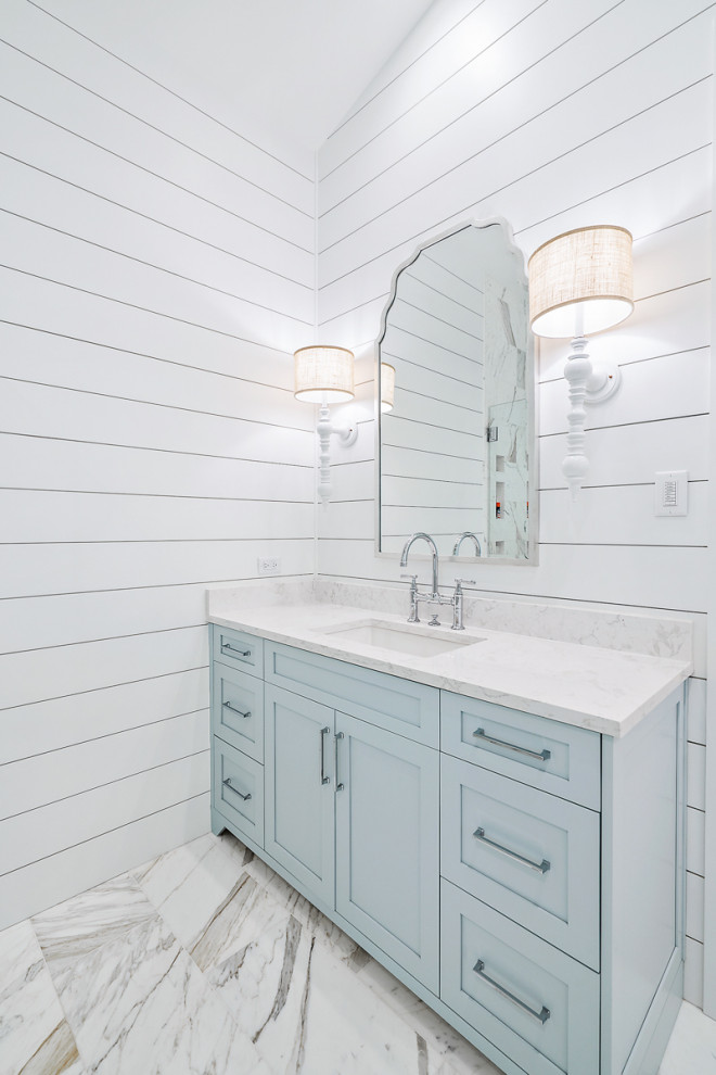 Ejemplo de cuarto de baño principal, único y de pie costero de tamaño medio con armarios con paneles lisos, puertas de armario azules, lavabo bajoencimera, encimera de cuarcita y encimeras blancas